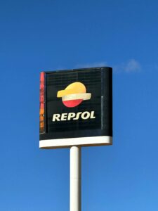 Repsol gas station sign against a clear blue sky in Valencia, Spain.